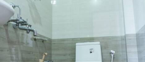 A bathroom with a toilet, a shower, and a bidet.