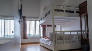 Quarto com beliche, janela, espelho e lixeira.