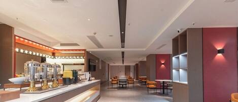 A modern hotel lobby with a reception desk, seating area, and built-in shelving.