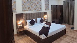 A modern hotel room with a large bed, two bedside tables with lamps, a headboard, and a large window with curtains.
