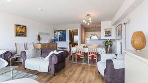 Ein modernes Wohnzimmer mit Essbereich, Holzboden und zeitgemäßen Möbeln.