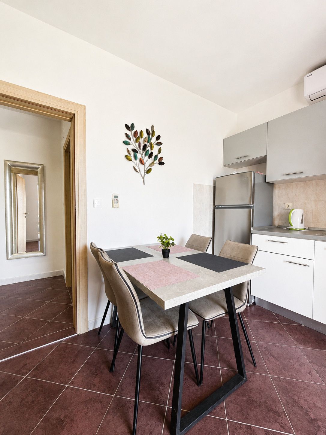 Uma cozinha moderna com mesa de jantar, cadeiras e um detalhe decorativo na parede.
