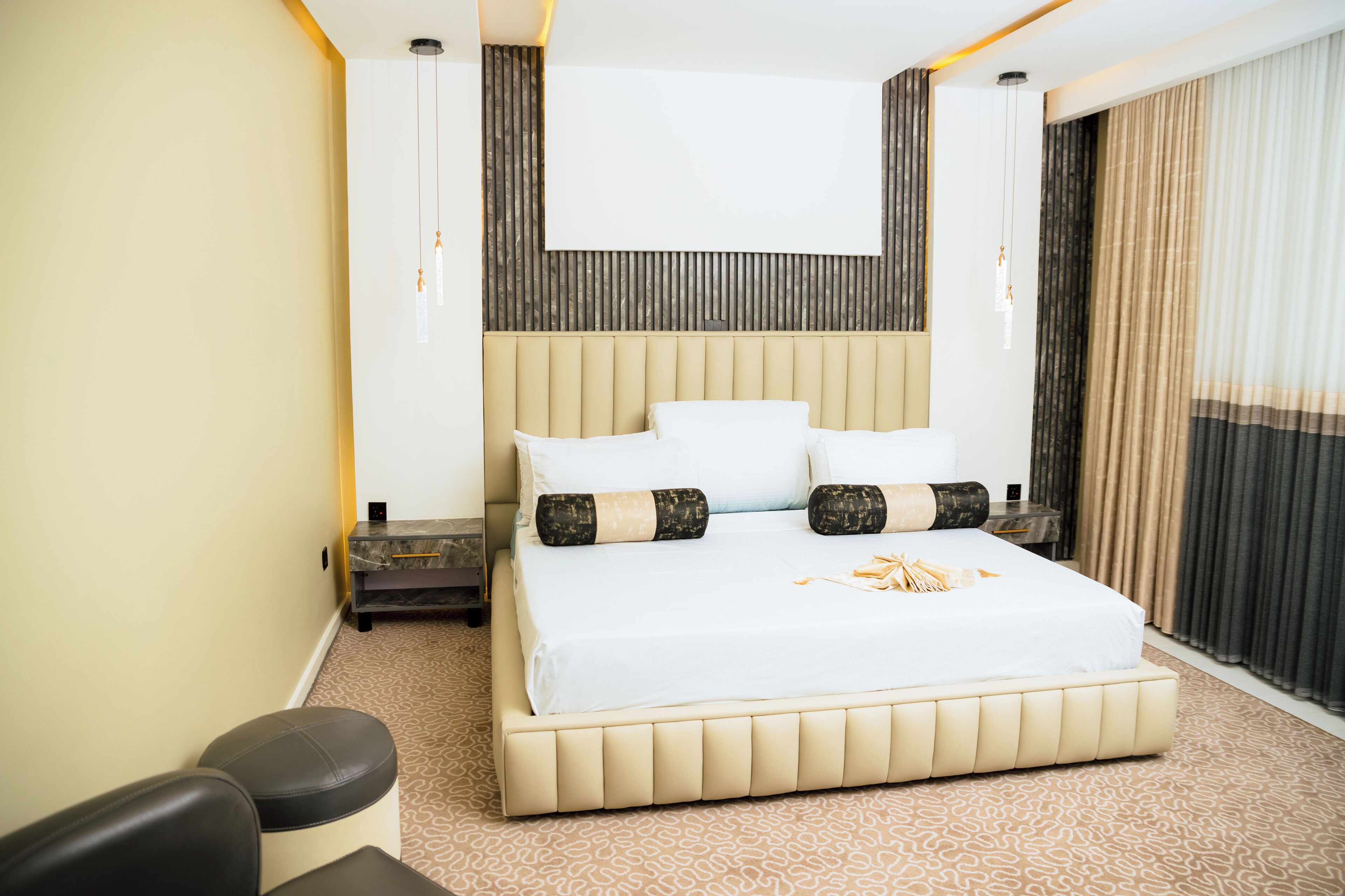 Hotellihuone, jossa on suuri sänky, yöpöytä ja oleskelualue.