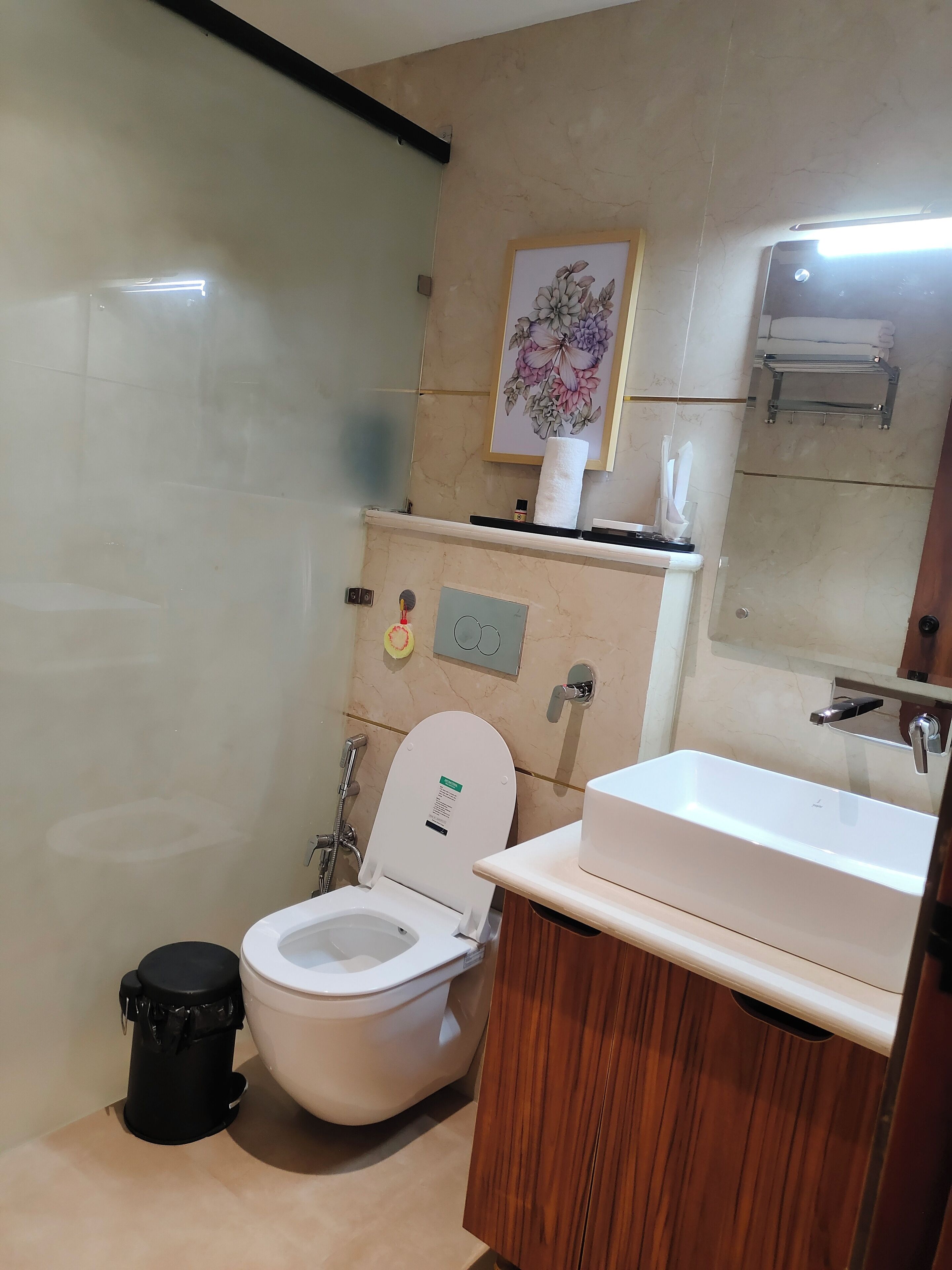 Casa de banho com sanita, lavatório e um contentor de lixo.