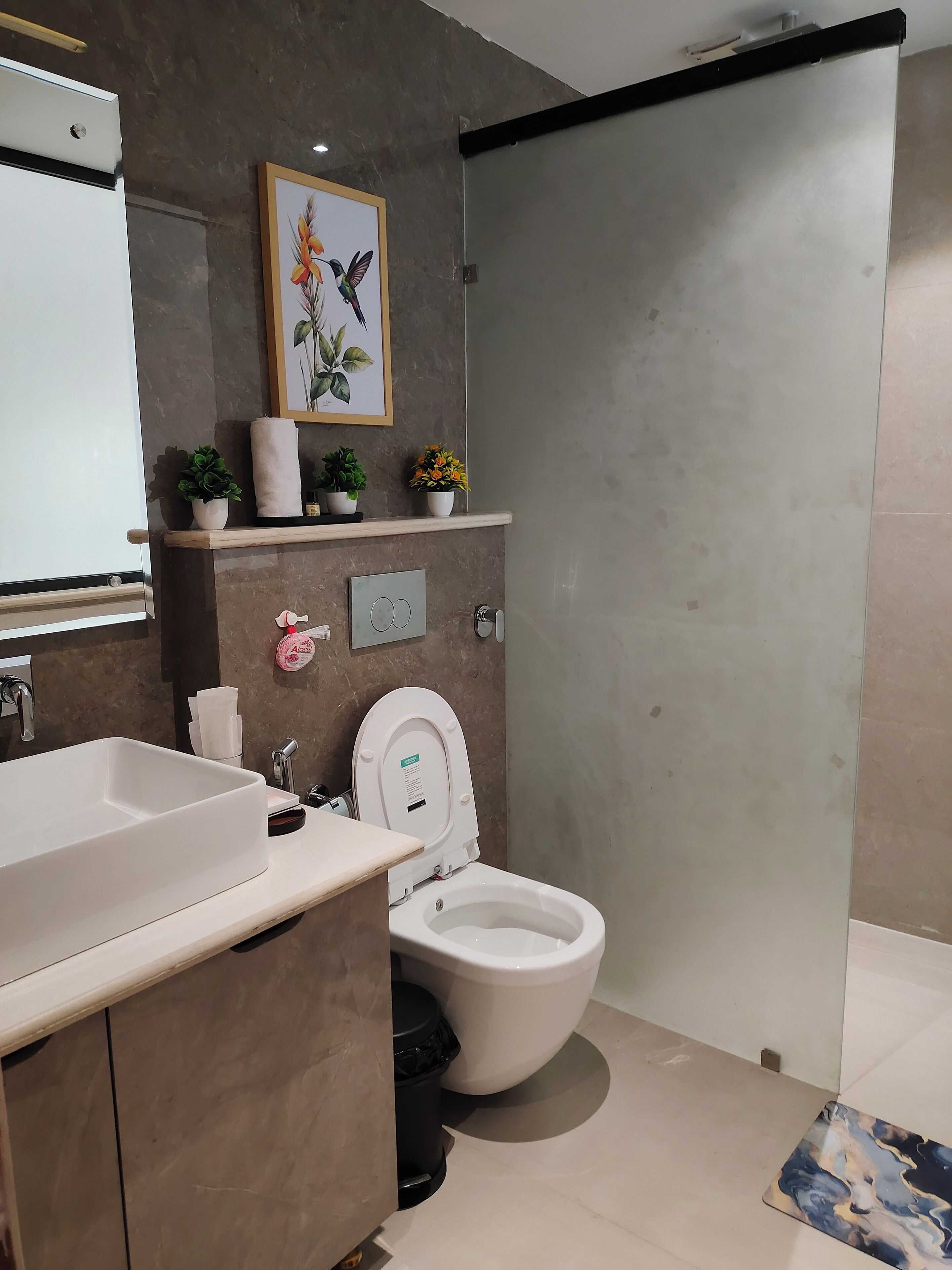 A modern bathroom with a large sink, toilet, and a shower area.