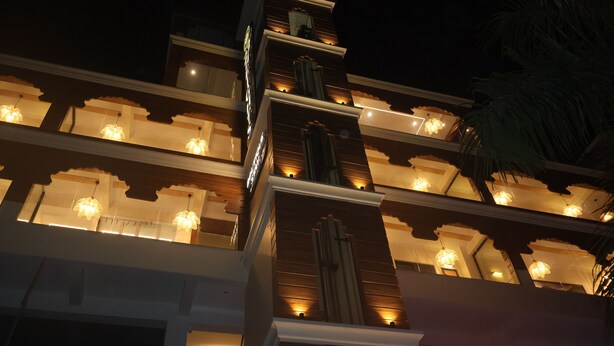 Un hôtel à plusieurs étages doté de balcons illuminés et d’une architecture moderne.