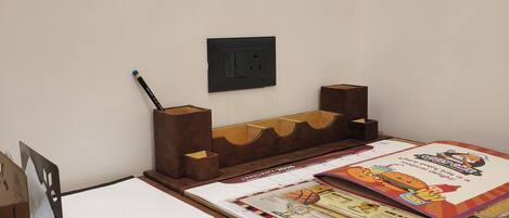 A wooden desk with a calendar, a pencil, and a small speaker.
