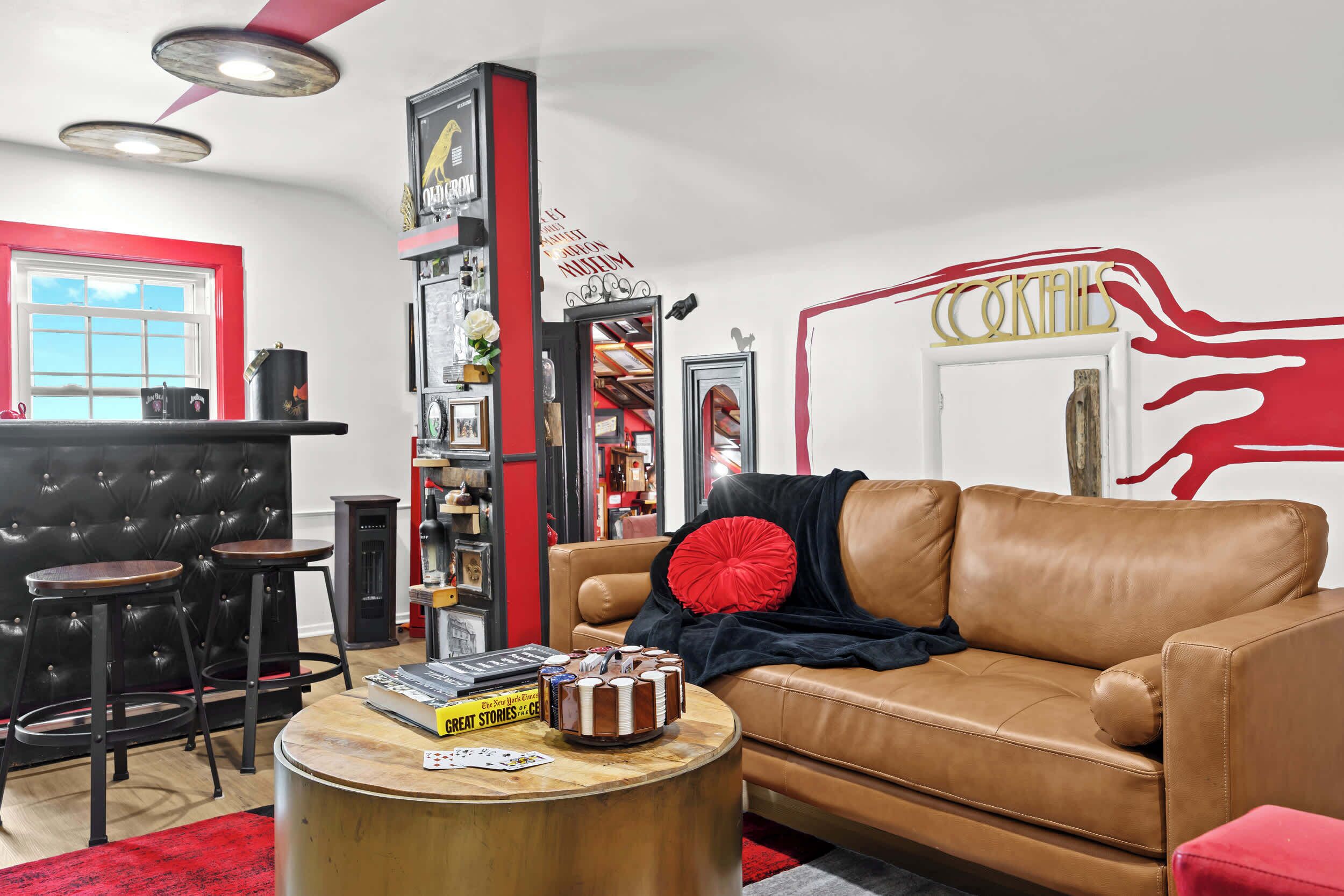A modern living room with a leather sofa, a coffee table, and a bar area with stools.
