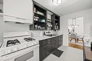 A modern kitchen with a gas stove, built-in cabinets, a microwave, and a sink. - 4 Spacious Units | Near Downtown & Expo Center! (Louisville)