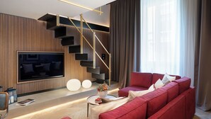 A modern living room with a red sofa, a flat-screen TV, a staircase, and a large window with curtains. - Arts & Crafts Apartments (Florence)