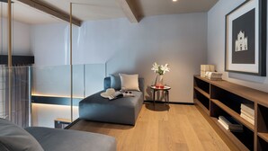 A modern bedroom with a sofa bed, bedside table, bookshelves, and a framed picture on the wall. - Arts & Crafts Apartments (Florence)