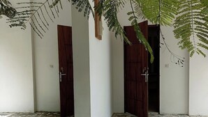 Un pasillo con dos puertas de madera y suelo de baldosas.