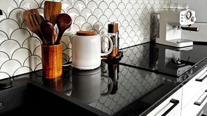 A kitchen with a black countertop, white cabinets, and a tiled backsplash. - Zinna Monastery Post Office (Jüterbog)