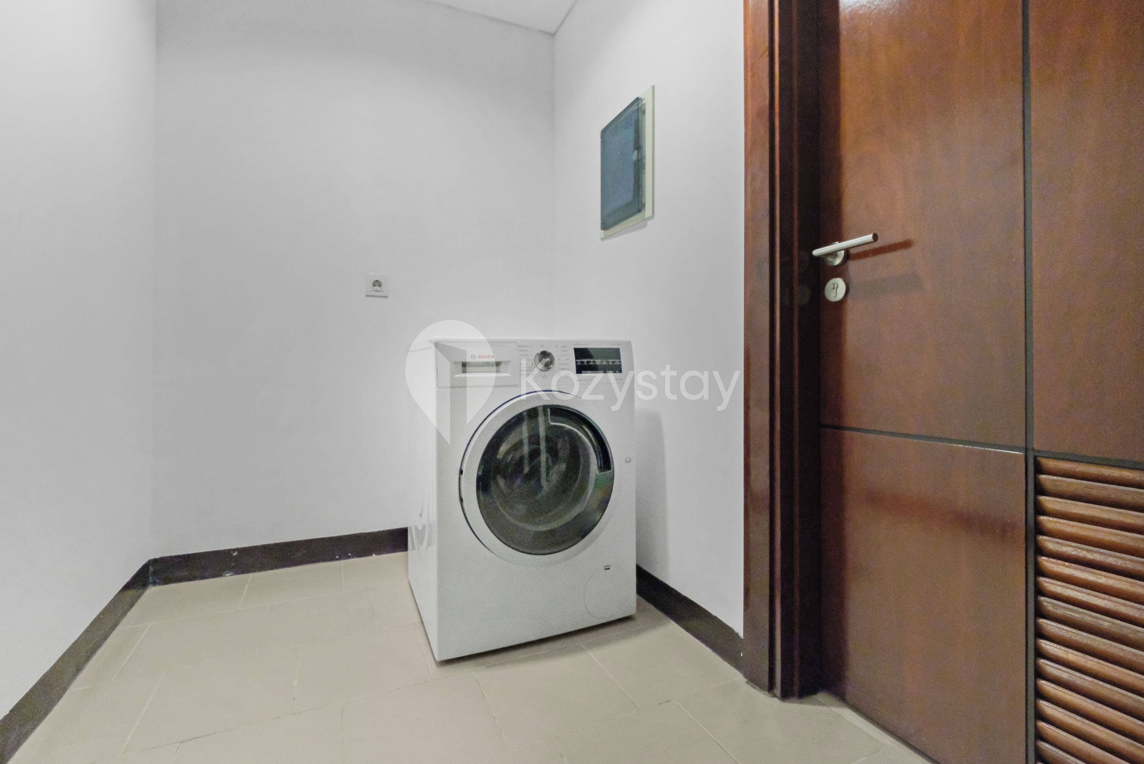 A compact room with a washing machine, a door, and a small window.
