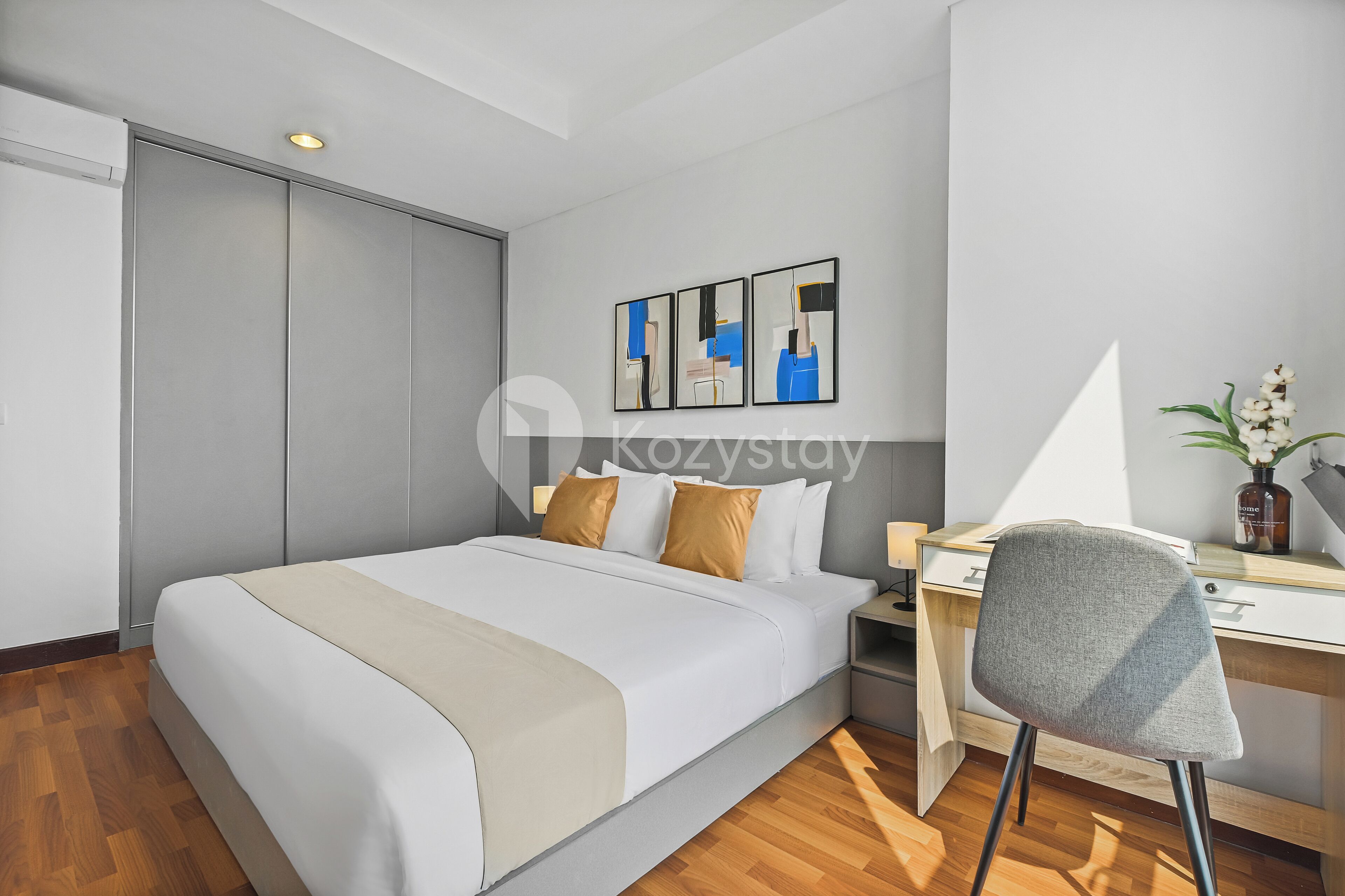 A modern hotel room with a bed, a desk, and a chair.