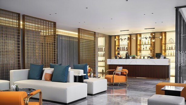Un moderno vestíbulo de hotel con recepción, zona de estar y bar.