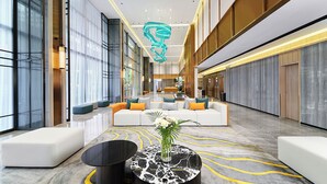 A spacious lobby with a central seating area, a marble floor, and a modern light fixture. - Harris Hotel & Suites Nagoya Batam (Batam)