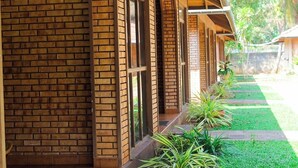 A row of brick buildings with large windows and a covered walkway. - Kumudu Valley Resort (Nainamadama)