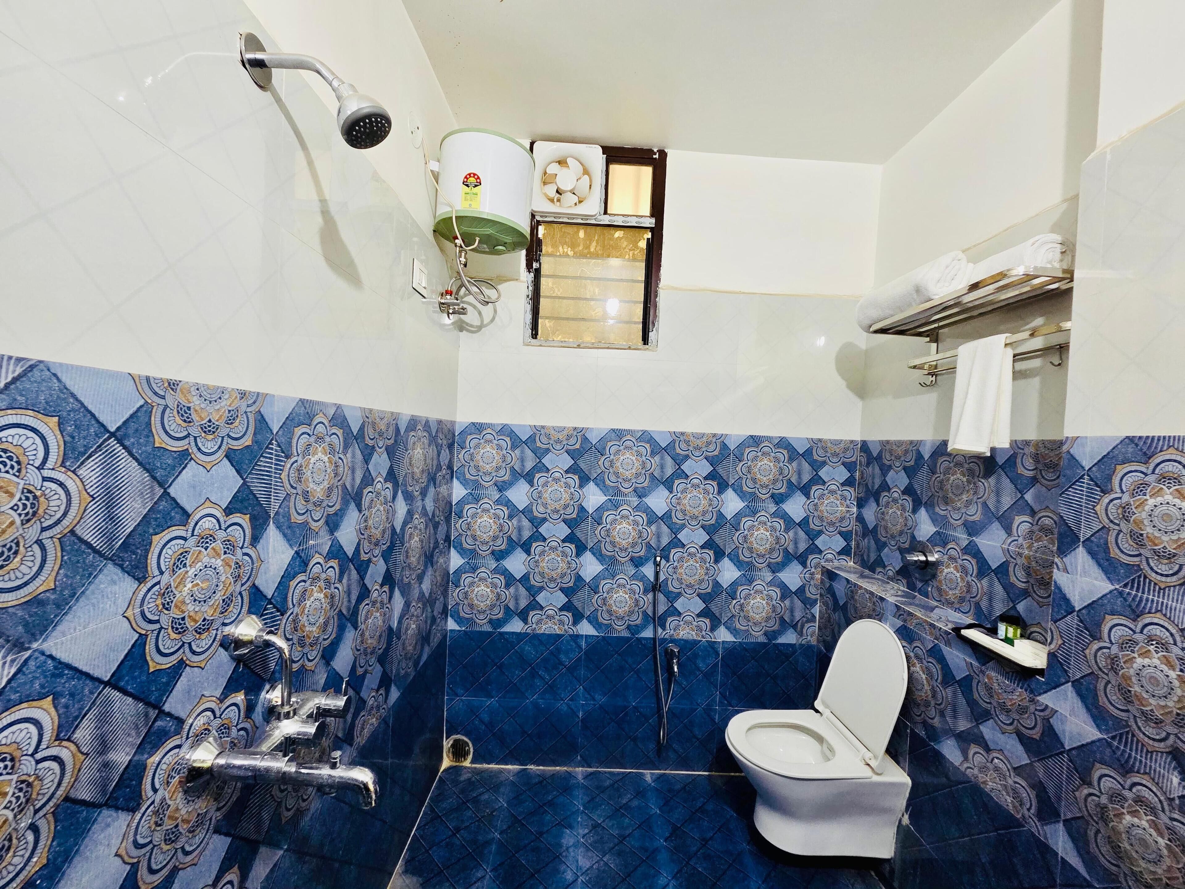 Une salle de bain avec douche, toilettes et lavabo.