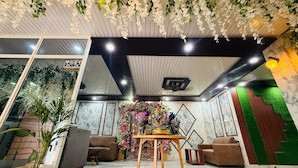 A reception area with a reception desk, sofas, and a decorative altar with flowers.