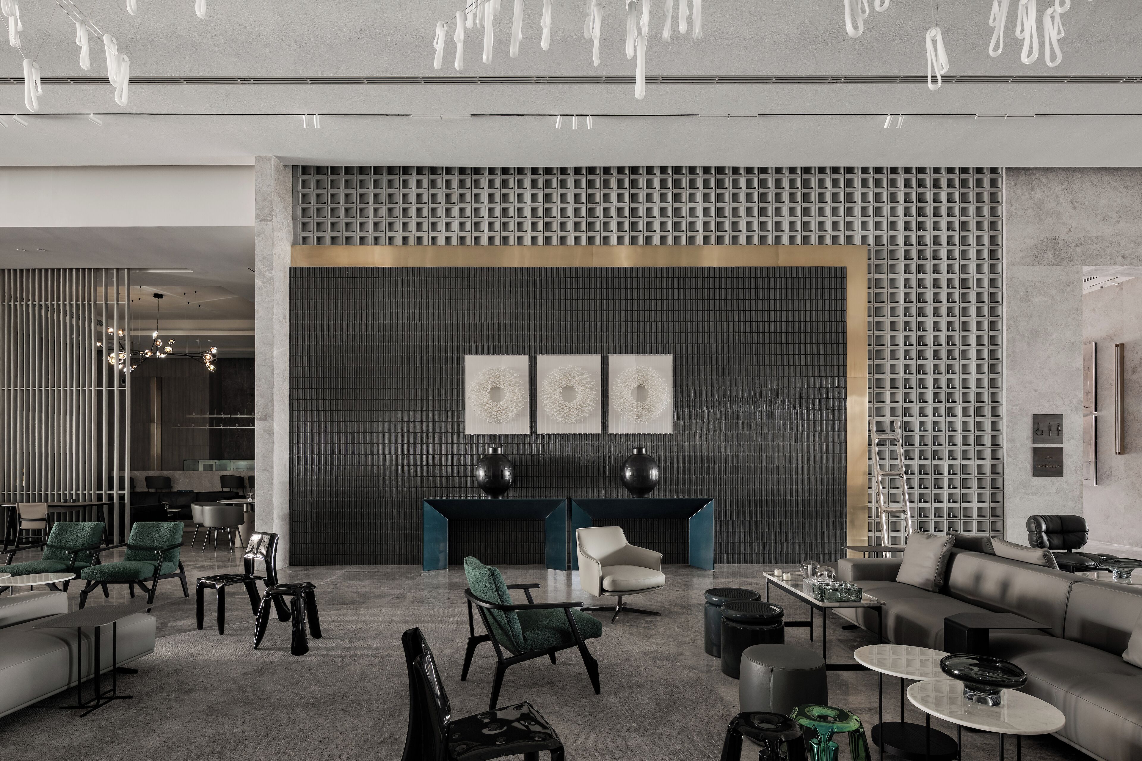 A modern lobby with a sectional sofa, green chairs, a coffee table, and a fireplace.