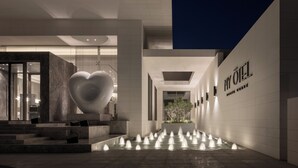 A modern hotel entrance with a heart-shaped sculpture, a water feature, and a sign reading "MY OIL". - My Ōtel North Coast (El Dabaa)