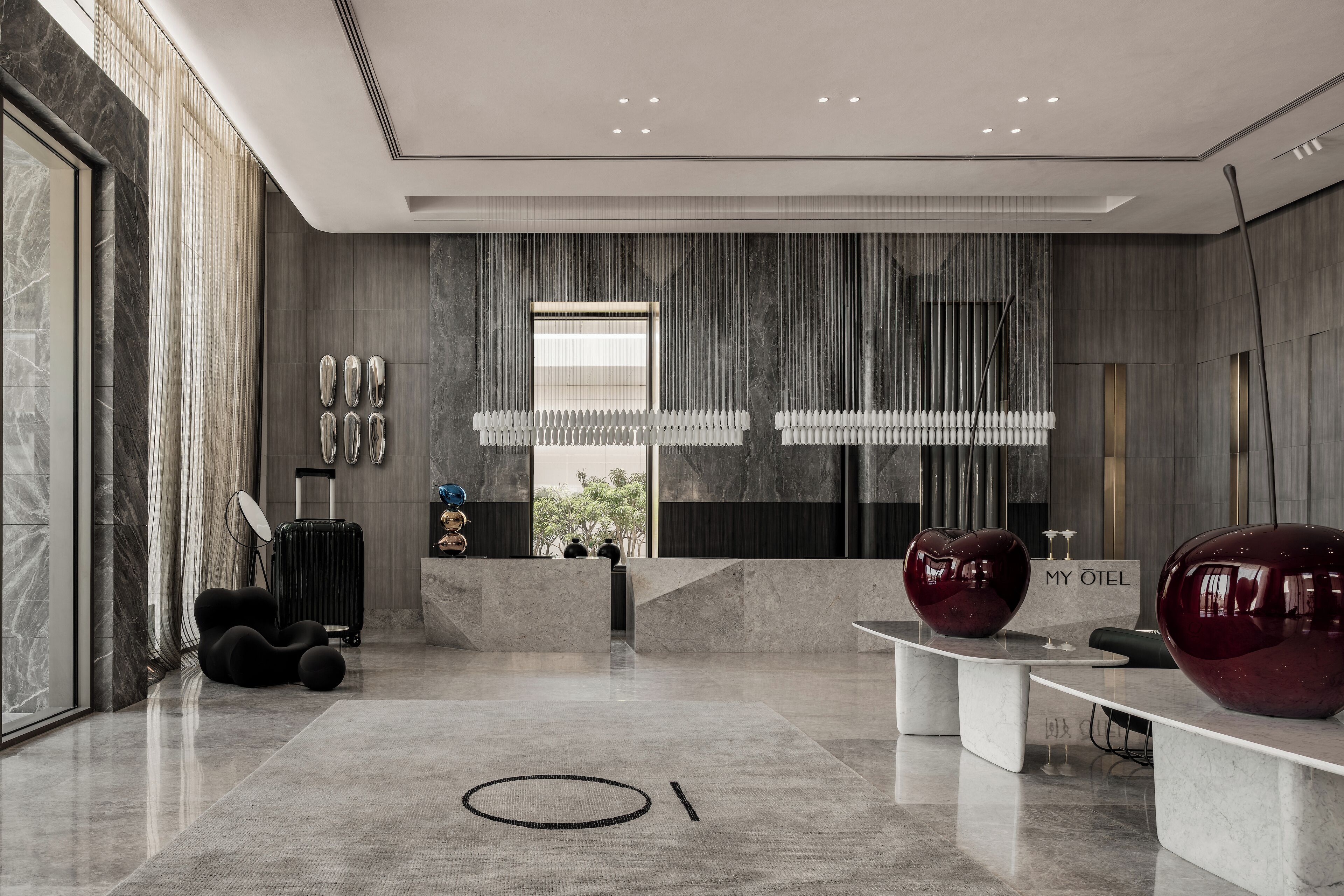 A modern lobby with a reception desk, seating area, and a view of the outdoors.