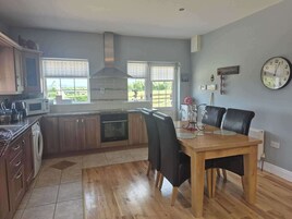 A modern kitchen with wooden cabinets, a built-in oven, and a large window.