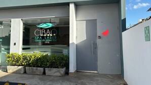 Un centre de bien-être doté d’une façade moderne, d’une entrée en verre et de plantes en pot devant l’entrée.