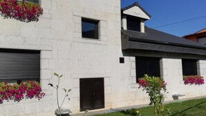 Un bâtiment moderne à deux étages, doté d’un toit plat, de grandes fenêtres et de jardinières au rez-de-chaussée.