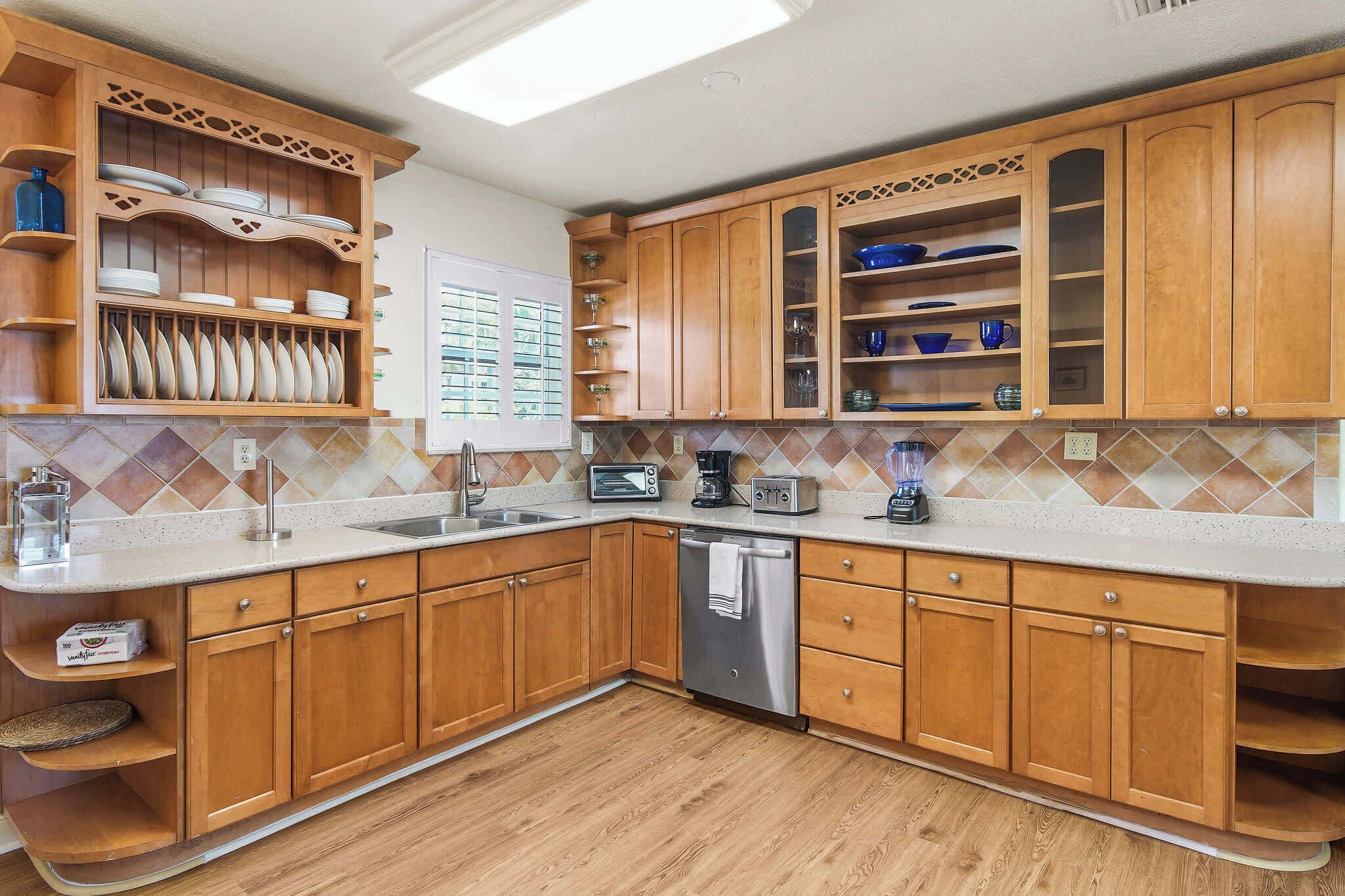 Una cocina con armarios de madera, lavavajillas y una encimera con tostadora y cafetera.