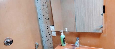 Un baño con lavamanos, espejo e inodoro.