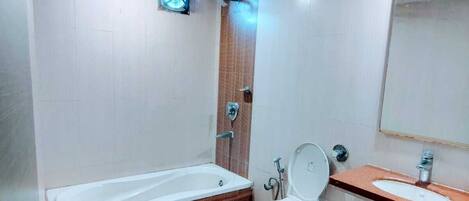 A bathroom with a bathtub, toilet, and sink.