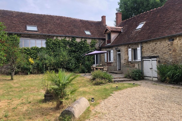Entrée de la maison et jardin clôturé.