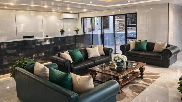 Een moderne woonkamer met twee banken, een salontafel en een keuken met een marmeren aanrecht.