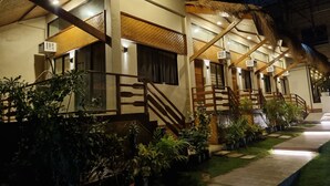 A row of hotel rooms with thatched roofs and wooden railings. - The CLiffhouse Samboan (Samboan)