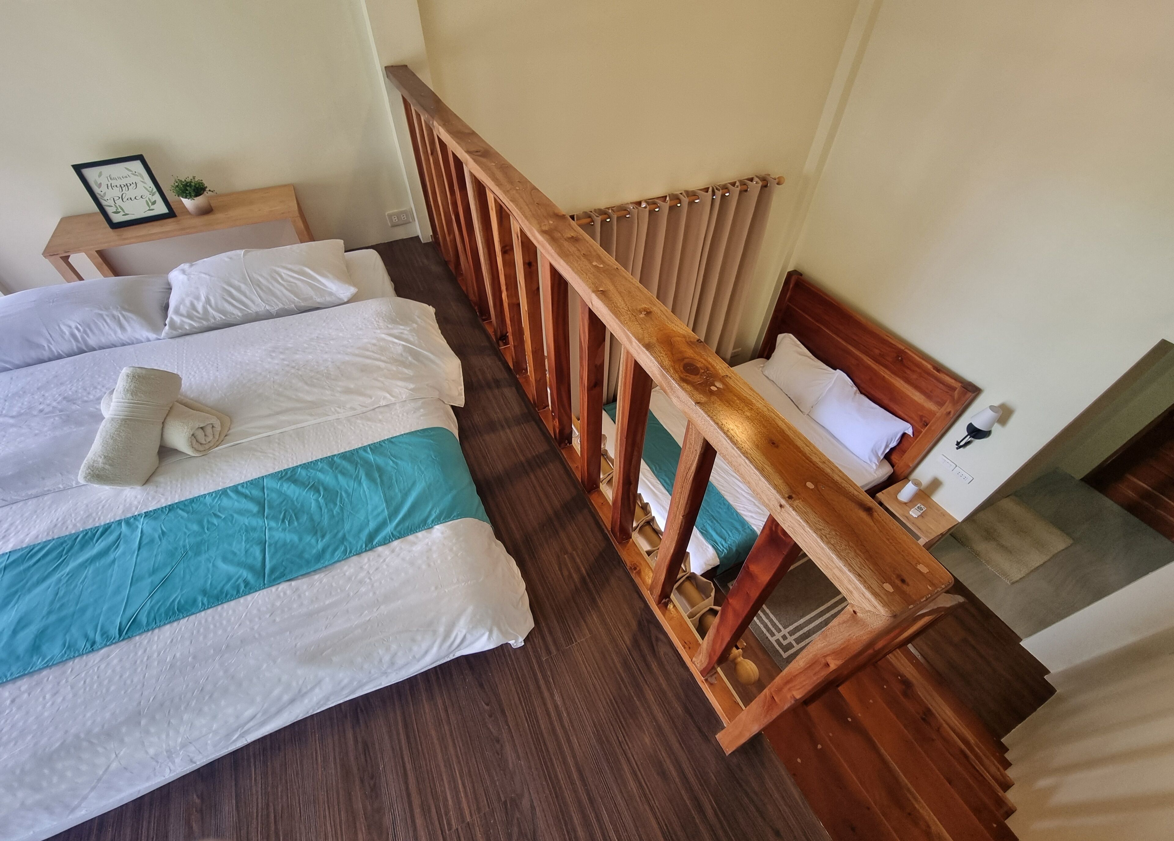 Camera d'albergo con un letto grande, una testiera in legno, un comodino con una pianta e vista all'esterno.