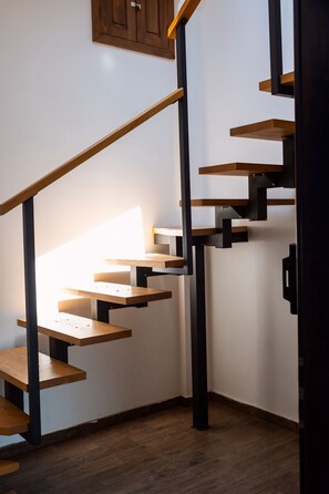 A staircase with wooden steps and black metal railings. - Kesletz House (Sibiu)