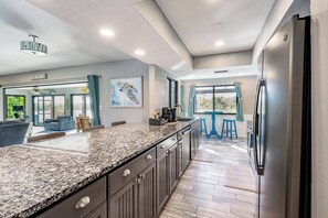 Una cocina moderna con encimeras de granito, electrodomésticos de acero inoxidable y una isla grande.