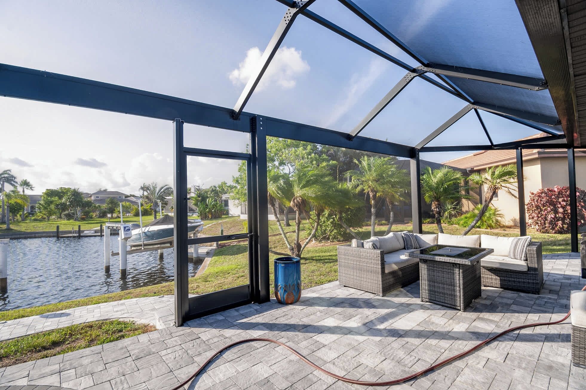 Een overdekt terras met uitzicht op een waterpartij en begroeiing.