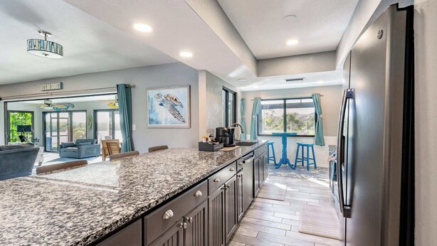 A modern kitchen with granite countertops, stainless steel appliances, and a large island.