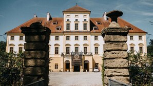 A historic building with a central entrance, flanked by stone pillars, and a sign indicating it is a university. - Versailles Royal Suite 3 Guests Aurolzmünster (Aurolzmünster)
