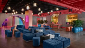 A modern lounge area with sofas, ottomans, and a foosball table. - Close to UT Austin + On-site Dining, Pool & Gym (Austin)