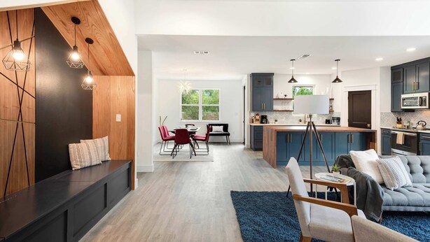 Una cocina moderna con armarios oscuros, una isla central e iluminación colgante.