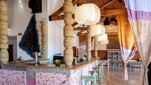 A bar area with rustic decor, including wooden beams and hanging paper lanterns. - Calipo (Vila Vicosa)