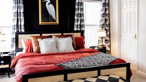 A bedroom with a bed, a ceiling fan, a window, and a door. - NEW Luxe Retro Sports Retreat~Walk to Stadiums (Raleigh)