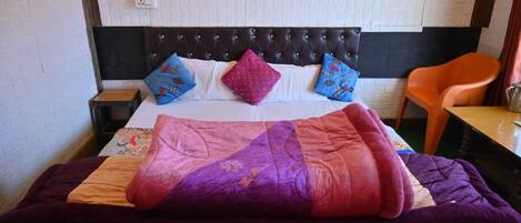 A bed with a quilt, pillows, and a blanket.
