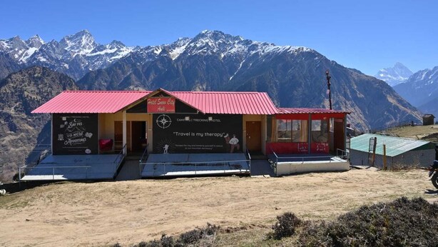 A small, red-roofed building with a sign that reads "Hotel Snow City." It has a simple, functional design with a flat roof and a small porch area. - The Snow City Auli (Auli)