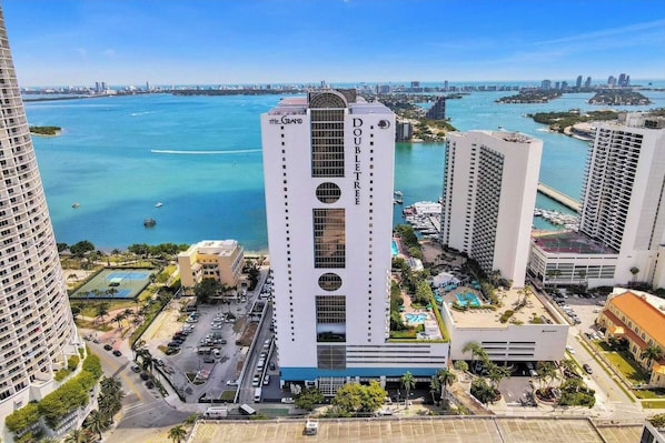 A high-rise hotel with a central atrium, surrounded by a marina and water views.