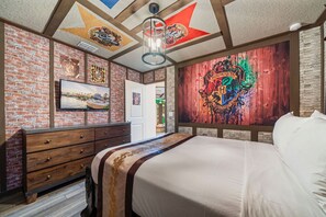 Camera d'albergo con parete in mattoni, un letto grande, una cassettiera e un soffitto decorato con stelle.